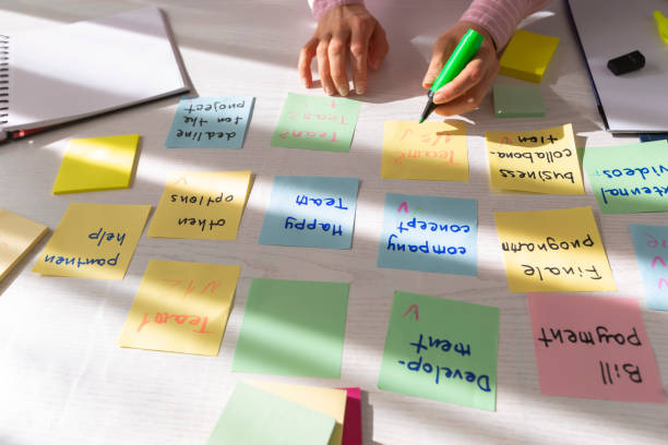 istock Business people write notes using stickers on paper. Brainstorming concept. Team meeting work on a project, develop ideas. 1307042895