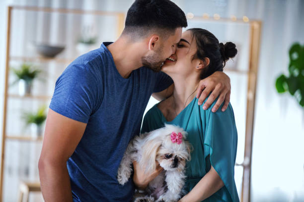istock Young couple at home enjoying with their dog. 1307044003