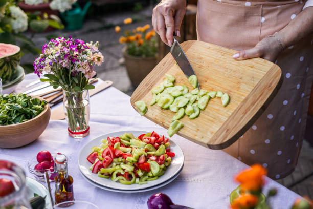 istock Putting chopped cucumber into vegetable salad 1307044357