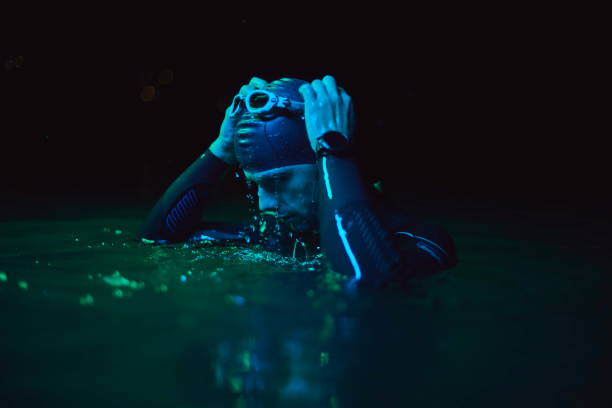 istock authentic triathlete swimmer having a break during hard training on night neon gel light 1307044548