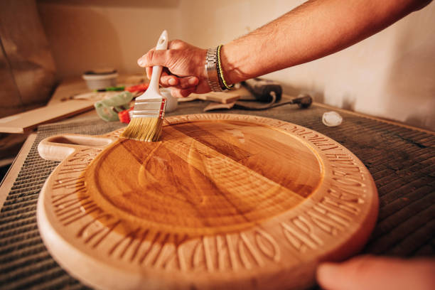 istock Carpenter applying varnish on wooden pedestal 1307049679