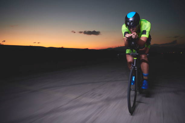 istock triathlon athlete riding bike fast at night 1307049686