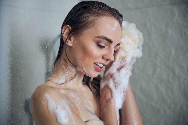 istock Pleased nice-looking woman daydreaming during the water procedure 1307050915