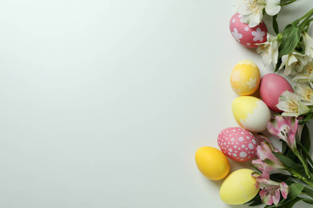 istock Color Easter eggs and alstroemeria flowers on white background 1307051226