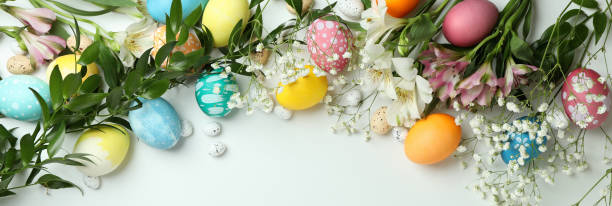 istock Easter eggs and beautiful flowers on white background, top view 1307051303