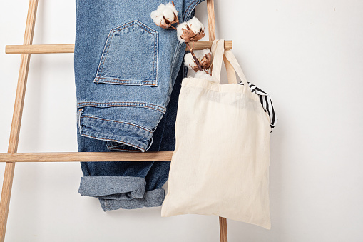 Mockup with organic cotton tote bag and jeans. Sustainable ethical consumption, zero waste, circular fashion concept