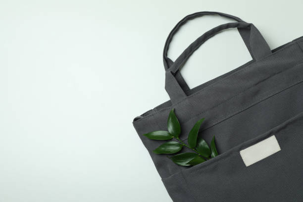 istock Stylish eco bag with twig on white background 1307052515