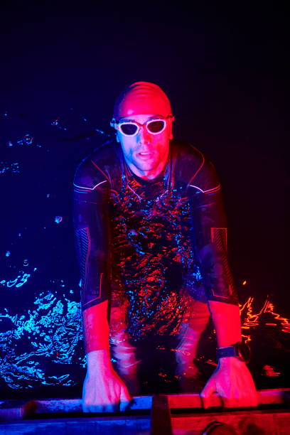 istock authentic triathlete swimmer having a break during hard training on night neon gel light 1307052866