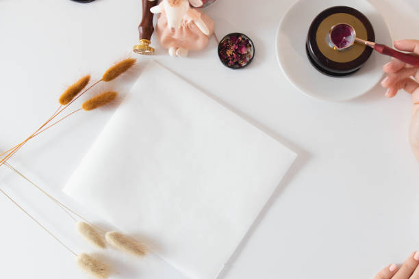 Girl melting some wax to seal an envelope on white table