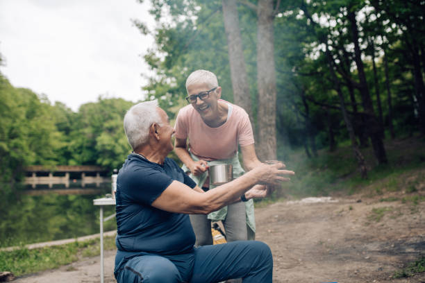 istock Happy seniors  drinking tea and enjoying camping by the river 1307057833