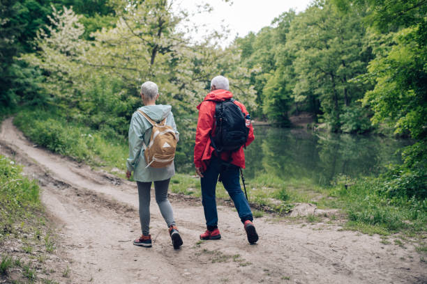 istock Senior man and woman walking by the river 1307057866