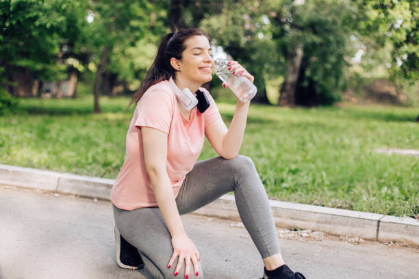 istock Happy girl refreshing with water after jogging 1307057960