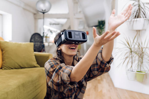 istock Portrait of a young woman using a a virtual reality headset at home 1307058355