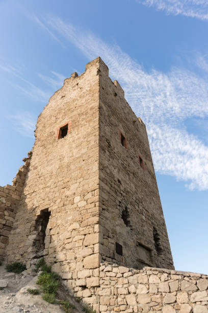 vista de abajo hacia arriba de la pared de piedra de la torre defensiva clement, la fortaleza medieval de kafa. cielo azul - kafa fotografías e imágenes de stock