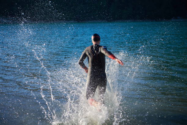 istock triathlon athlete starting swimming training on lake 1307061037