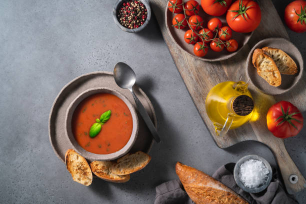 zuppa di pomodoro su ciotola e ingredienti su sfondo grigio - gazpacho salsa vegan food freshness foto e immagini stock