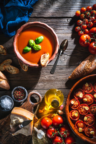 istock Tomato soup with roasted tomatoes, basil, ingredients  and toasted bread on rustic wood 1307062139