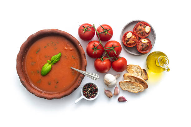 tomatensuppe mit gerösteten tomaten, basilikum, zutaten und geröstetem brot auf weiß - tomato soup red basil table stock-fotos und bilder