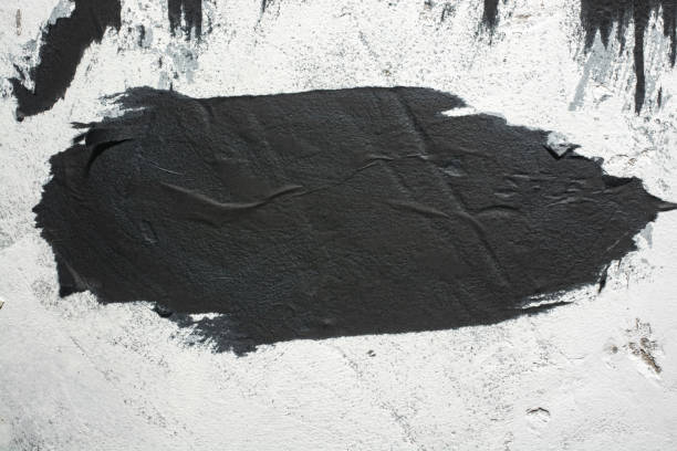 istock Scraps of black paper on a white plastered wall. 1307065325