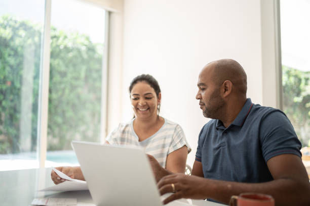 pareja madura haciendo finanzas domésticas - home finances couple computer african ethnicity fotografías e imágenes de stock