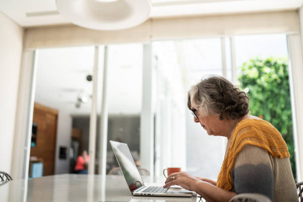 istock Senior woman using laptop at home 1307065506