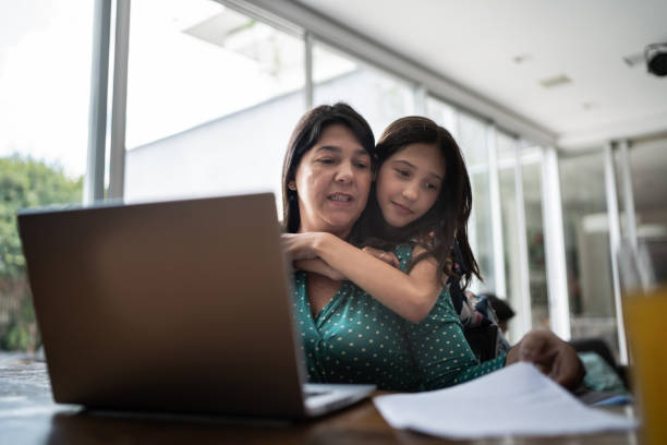 istock Mature woman working at home with daughter embracing her 1307065770