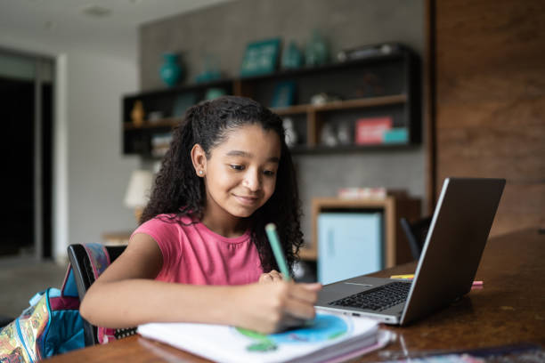 istock Happy girl drawing planet earth on her note pad during homeschooling 1307065849