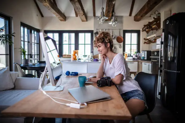 Photo of Young photographer working in her home office