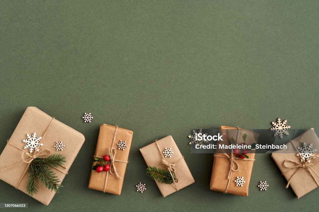 Christmas presents wrapped in ecological recycled paper with wooden decoration and wintergreen - zero-waste concept Christmas presents wrapped in ecological recycled paper with wooden decoration and wintergreen - zero-waste concept, top view Wrapping Paper Stock Photo