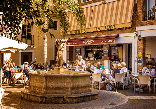 Small café at Plaza Higuitos in the centre of Almunecar with a fountain in the middle.