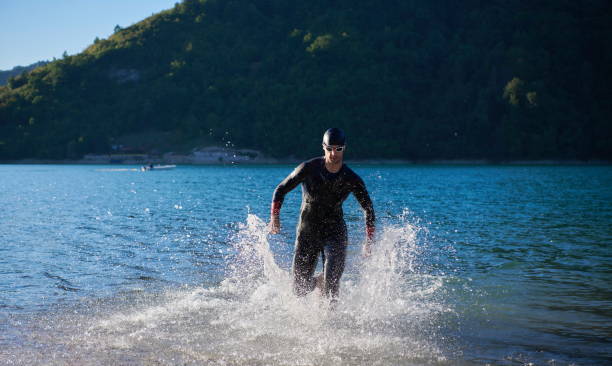 istock triathlon athlete starting swimming training on lake 1307070954