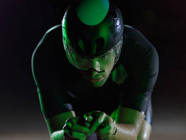 istock triathlon athlete riding bike at night 1307072544