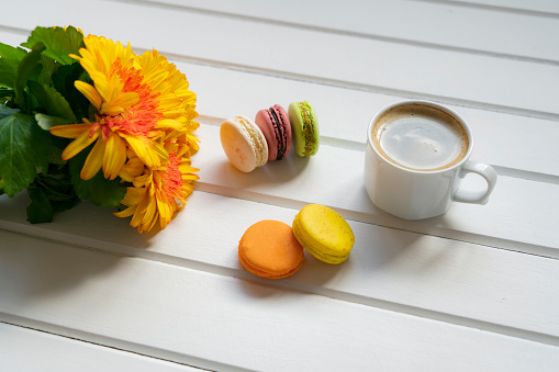 coffee, cake macaron and flower on wood