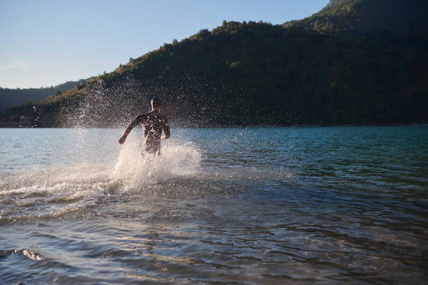 istock triathlon athlete starting swimming training on lake 1307075966