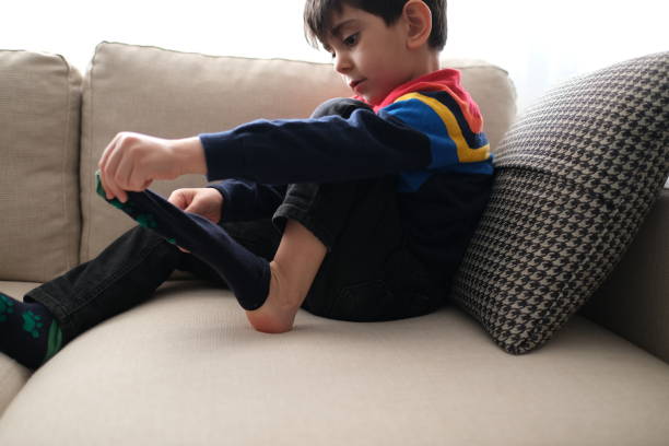 istock Adorable little boy trying to put a socks. 1307079472