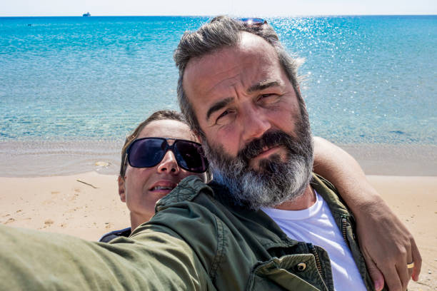 istock Middle aged couple taking selfie by the sea 1307079510
