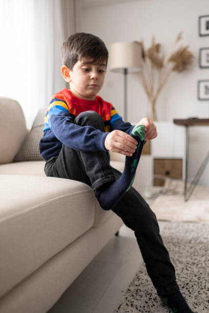 istock Adorable little boy trying to put a socks. 1307079601