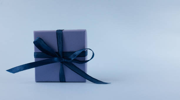 istock blue gift with blue ribbon on light blue background with copy space. 1307079815
