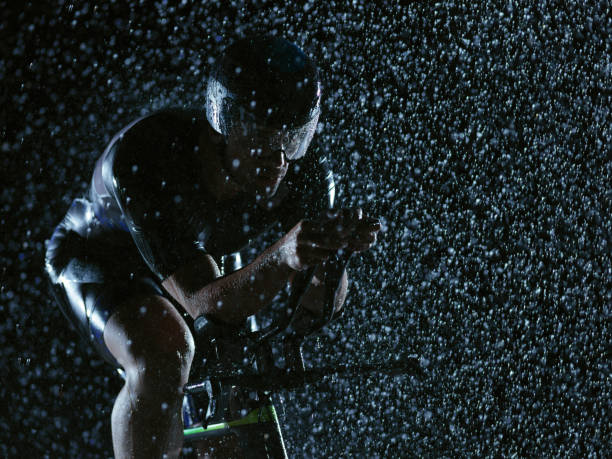 istock triathlon athlete riding bike on rainy night 1307081301
