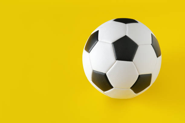 istock Classic soccer ball on yellow background. 1307081369