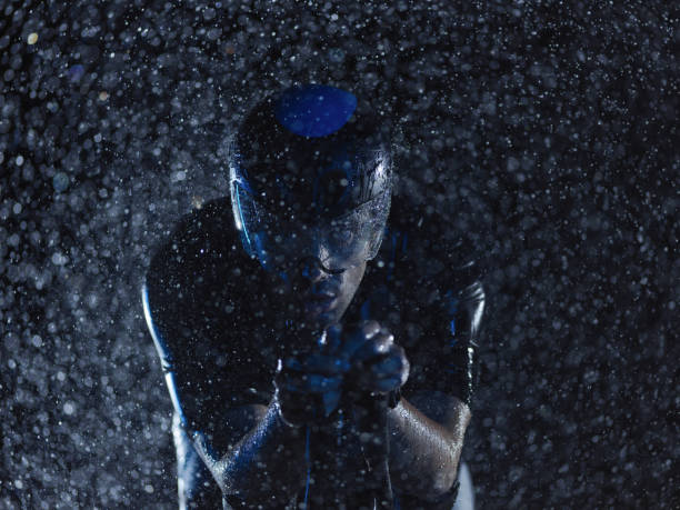 istock triathlon athlete riding bike on rainy night 1307082242