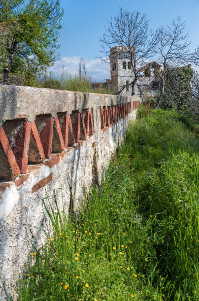 istock Small old wall, with a country house 1307084946
