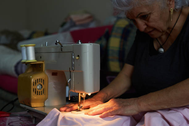 istock A woman making buttonhole on the quilt cover on the sewing machine 1307085189