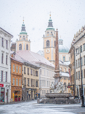 Ljubljana Town Square with Ljubljana cathedral and three bridges fountain during snowfall, Central Slovenia Region