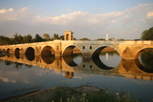 Historic Meric Bridge Over the Meric River, Reflection, Sunset Edirne, Turkey-August 15, 2015: Historic Meric Bridge Over the Meric River. It is a bridge from the Ottoman Empire period. It was built in 1847 during the reign of Sultan Abdulmecit. The river is dry due to the drought. ancient arch architecture brick stock pictures, royalty-free photos & images