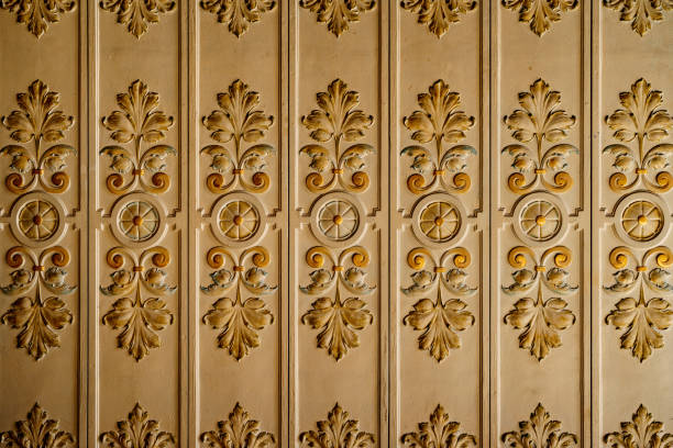 The molding with leaf patterns on the ceiling is white and gold. High quality photo