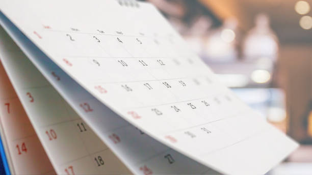 Close up white paper desk calendar with blurred bokeh background appointment and business meeting concept Close up white paper desk calendar with blurred bokeh background appointment and business meeting concept calendar page stock pictures, royalty-free photos & images