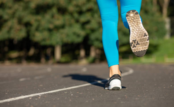 istock Fitness woman feet during running workout train on the stadium. Empty space 1307099138
