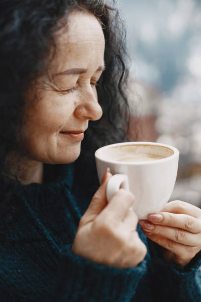 istock Middle-aged woman drinking coffee on balcony in winter alone 1307100172