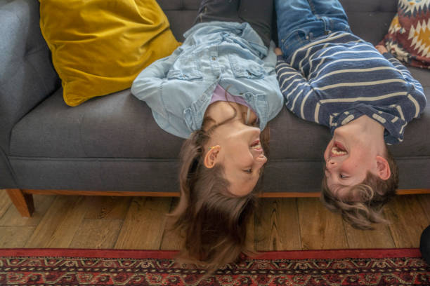 istock Siblings Hanging Upside Down On Their Sofa At Home 1307103279
